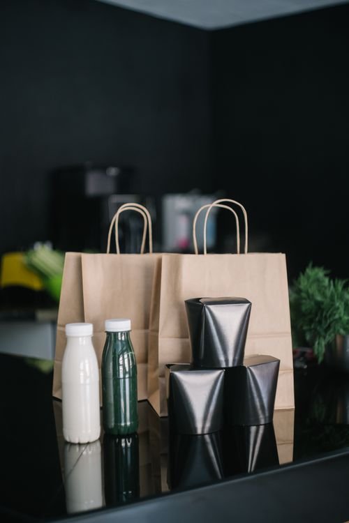 Restaurant takeout bags and packaged food representing delivery order accuracy and handoff control